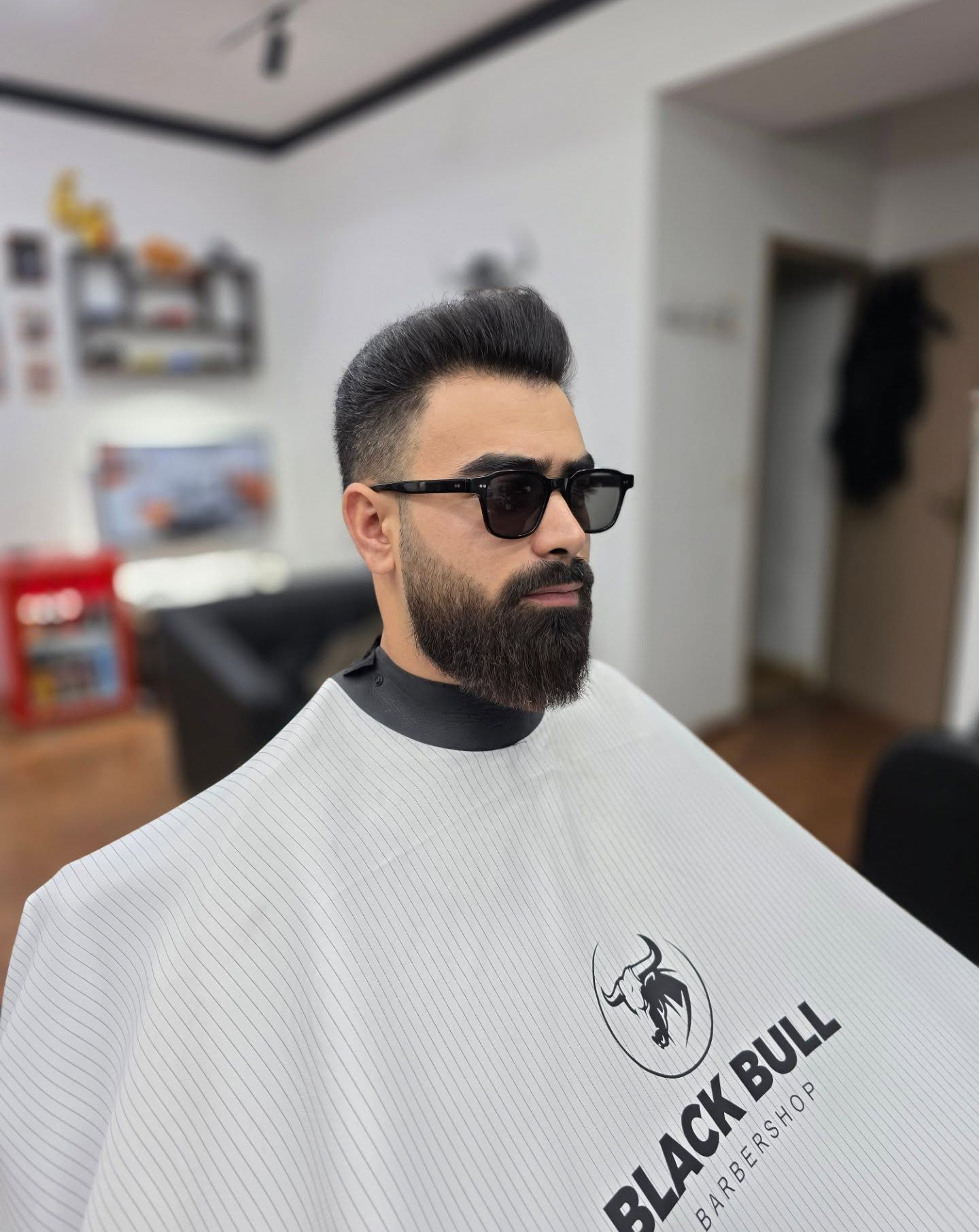 კლიენტი პომპადურით და წვერით Black Bull Barbershop-ის სავარძელში